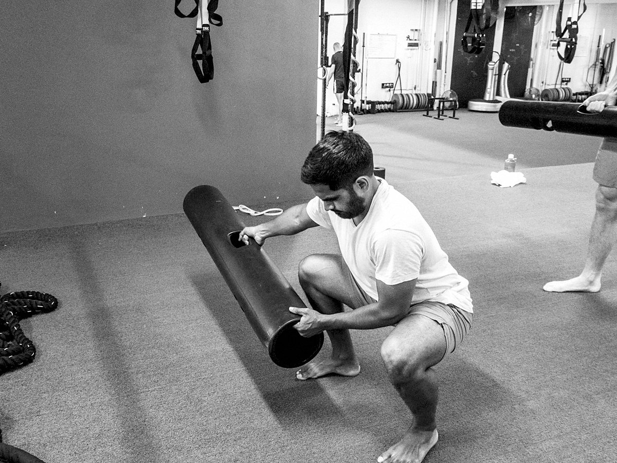 Athlete training in a gym with a foam roller